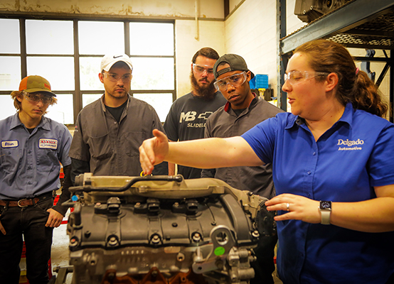 instructor in front of an engine block with students