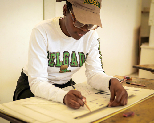 black female working on a project at a drafting table