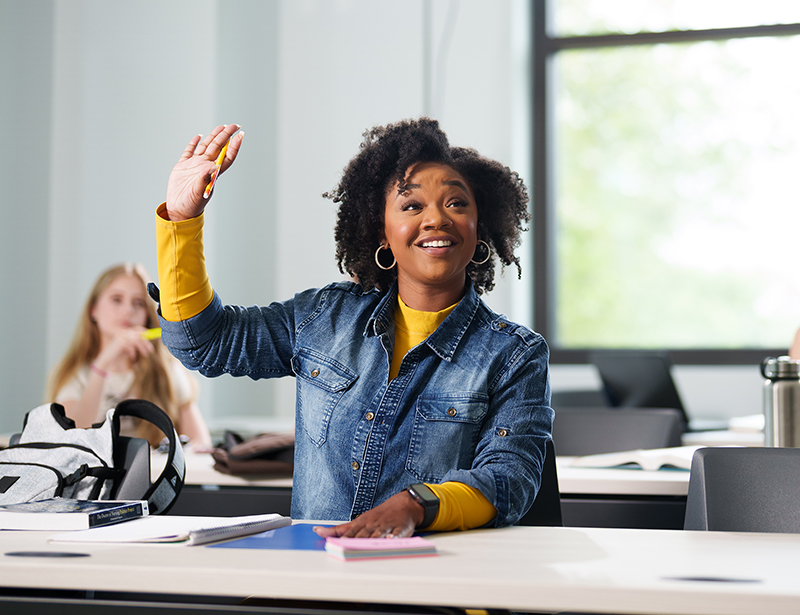 black female raising her hand in class