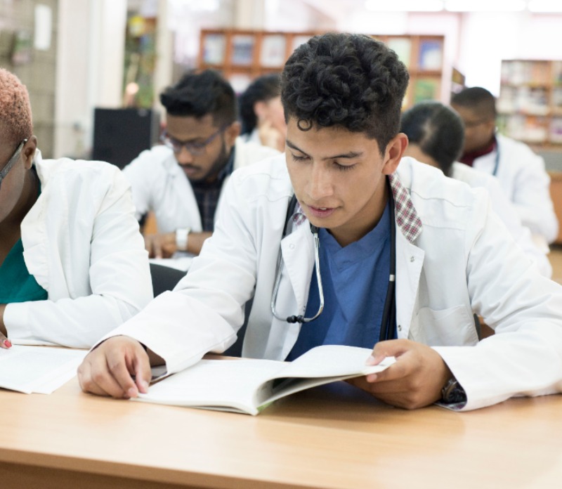 group of students in lab coats studying