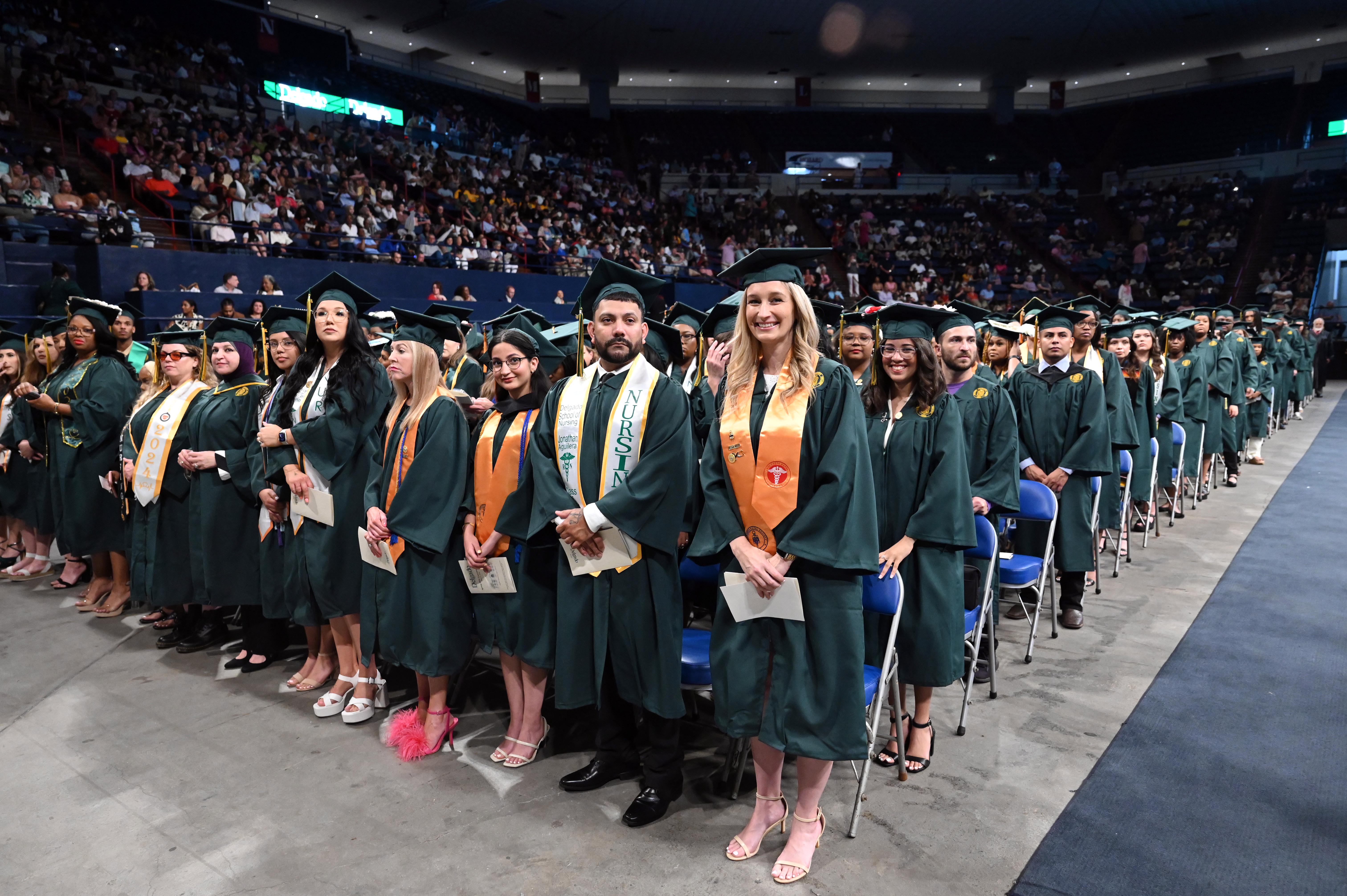 Graduates standing at their seats