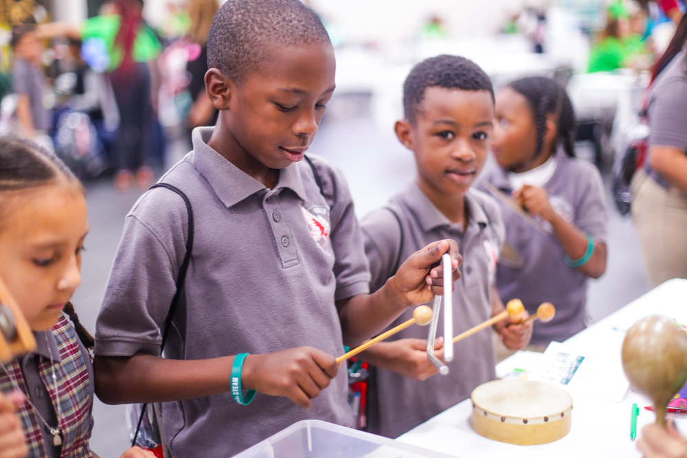 Young students play percussion instruments