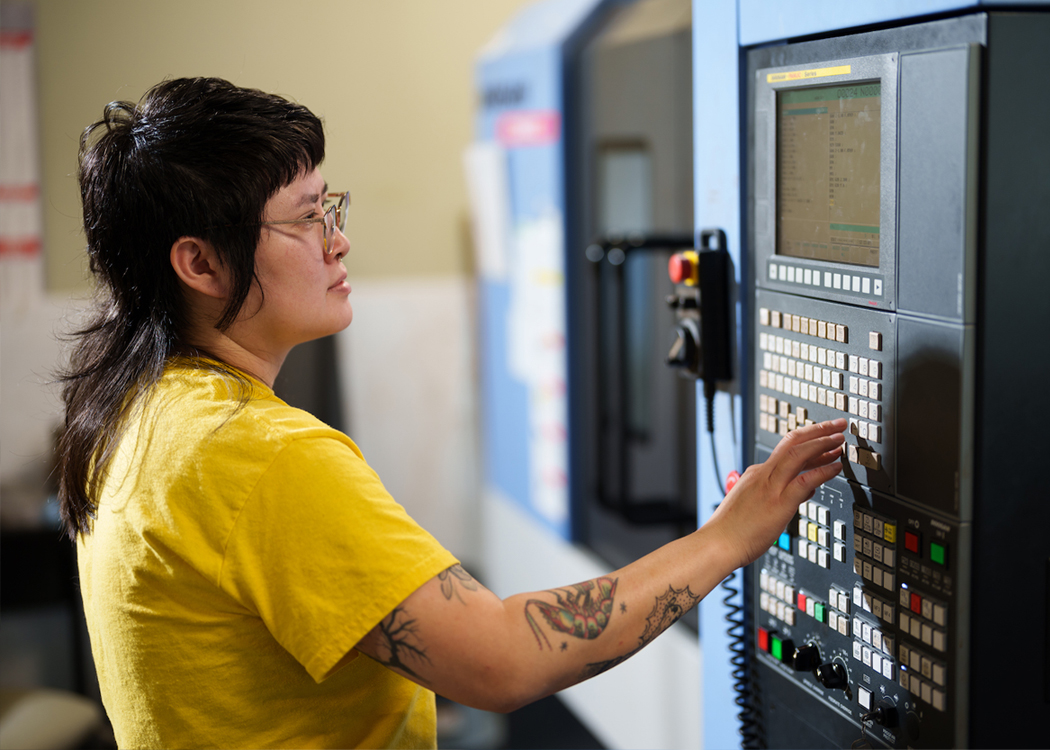 female student pushing buttons on an instrumentation machine